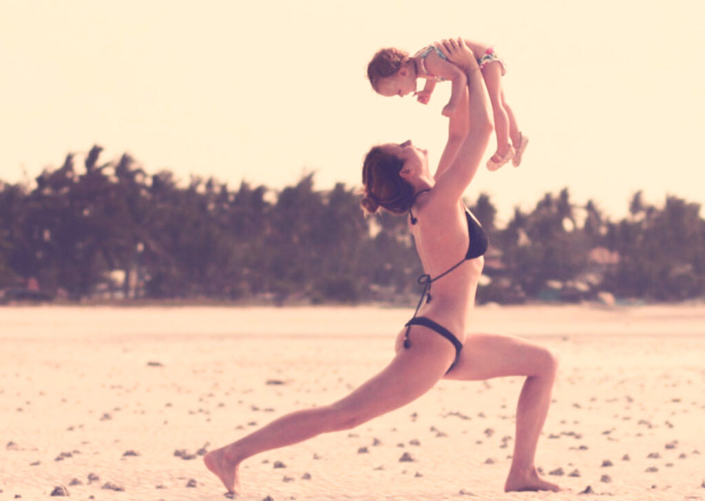 Auf diesem Foto siehst Du eine Mama, die mit ihrem Kleinkind Yoga macht