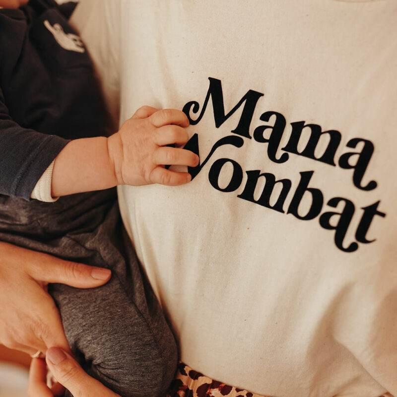 Auf diesem Foto siehst Du eine Mama mit einem Baby auf dem Arm und dem Aufdruck Mama Wombat