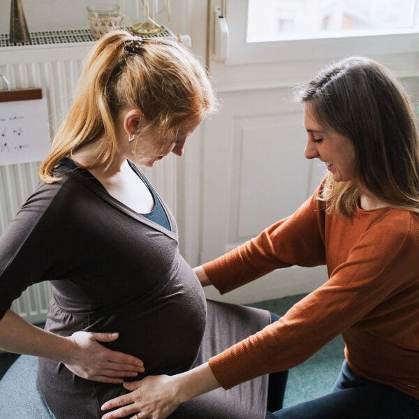 Auf diesem Foto siehst Du eine schwangere Frau, die von ihrer Hebamme umsorgt wird. Im Blog geht es um die Betreuungsformen in der Schwangerschaft